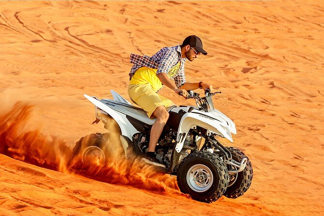 Adventurer riding a quad bike through golden dunes during Quad Bike Desert Safari Dubai.