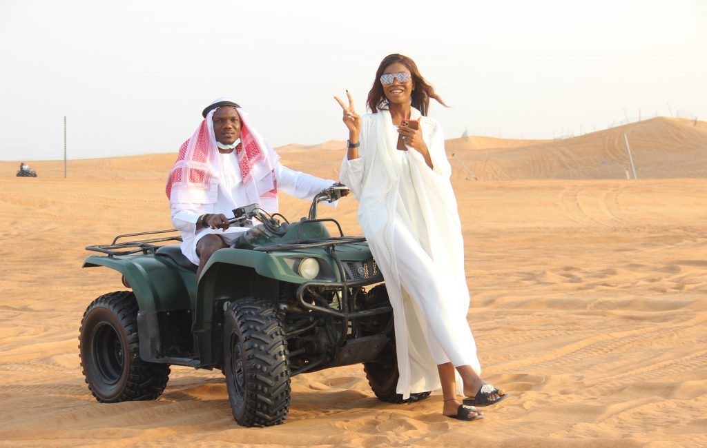 Tourists enjoying a thrilling dune buggy Dubai adventure in the golden desert.
